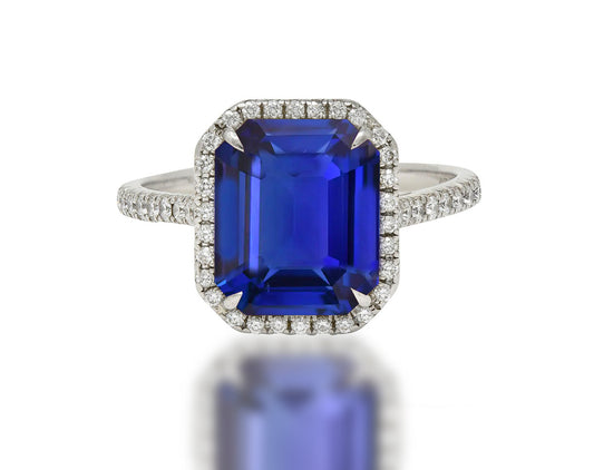 555 custom made unique emerald cut blue sapphire center stone and round diamond halo engagement ring