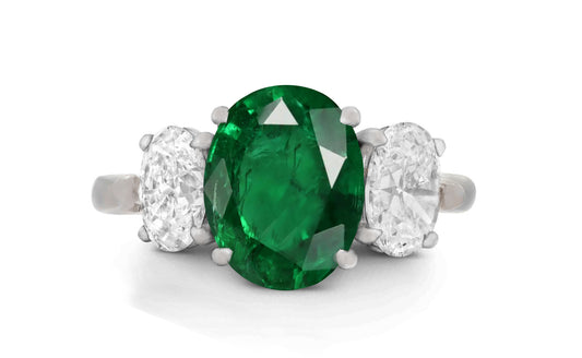 646 custom made unique oval emerald center stone and oval diamond accent three stone engagement ring