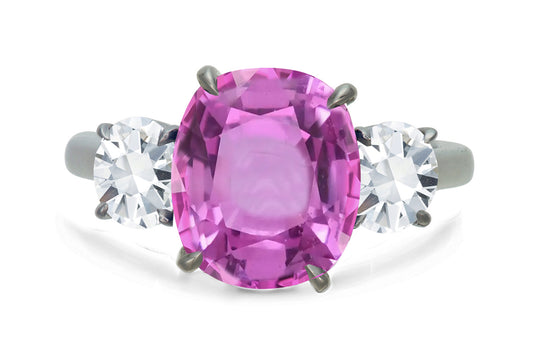 650 custom made unique oval pink sapphire center stone and round diamond accent three stone engagement ring