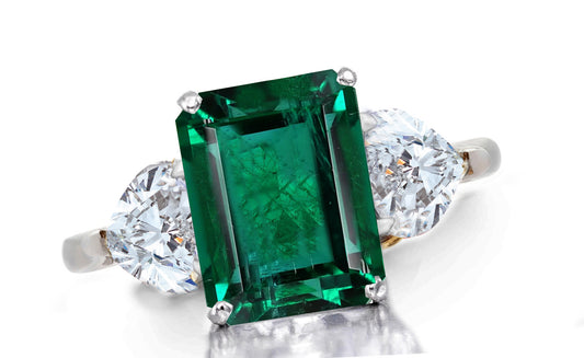 657 custom made unique emerald cut emerald center stone and heart diamond accent three stone engagement ring