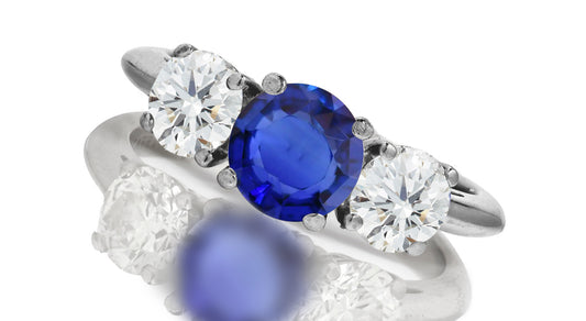 667 custom made unique round blue sapphire center stone and round diamond accent three stone engagement ring