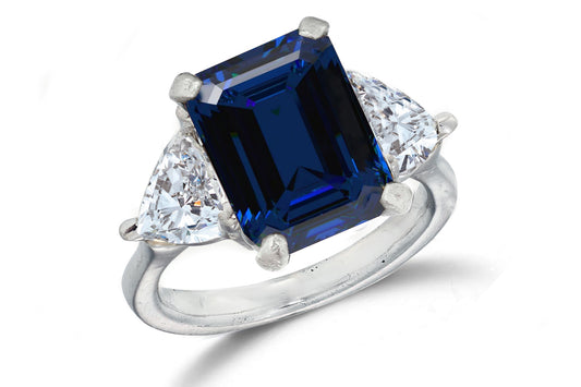 669 custom made unique emerald cut blue sapphire center stone and heart diamond accent three stone engagement ring