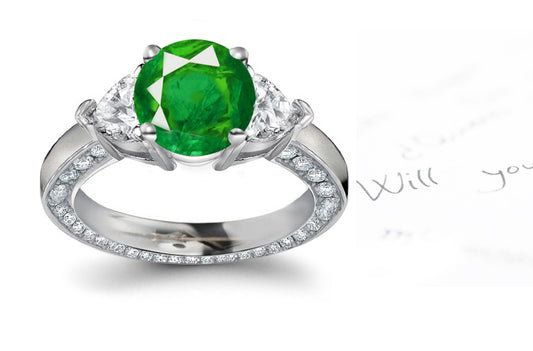 engagement ring with round emerald center and heart/round diamond accents band