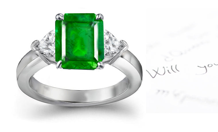 engagement ring three stone with emerald cut emerald center and side heart diamonds