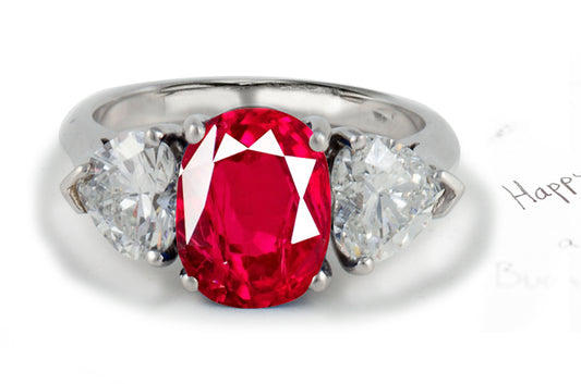 engagement ring three stone with oval ruby center and side heart diamonds