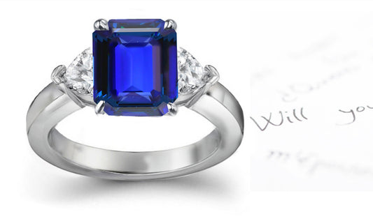 engagement ring with emerald cut blue sapphire center and side heart diamonds