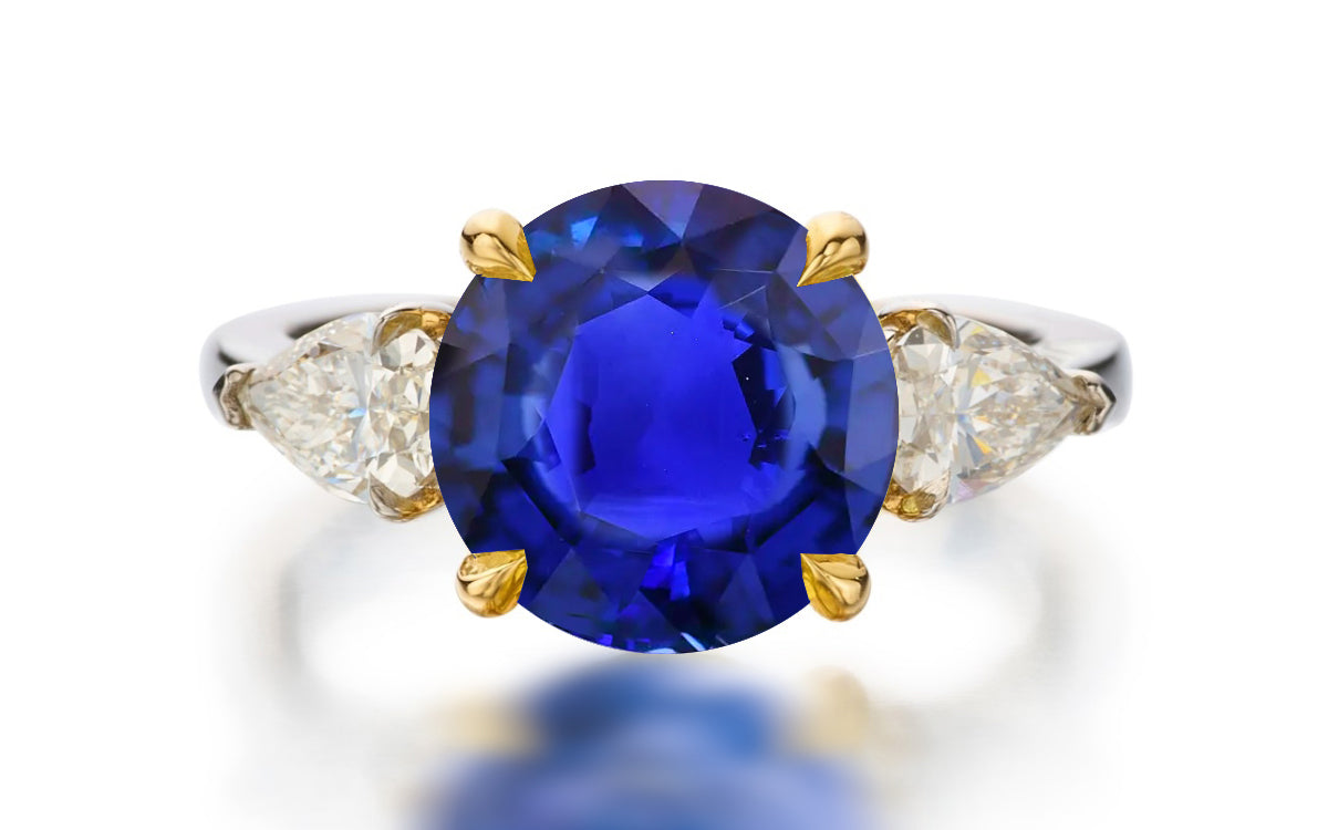 122 custom made unique round cut blue sapphire center stone and pear cut diamond side three stone engagement ring