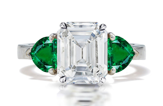 126 custom made unique emerald cut diamond center stone and heart emerald side three stone engagement ring