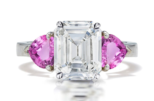 126 custom made unique emerald cut diamond center stone and heart pink sapphire side three stone engagement ring