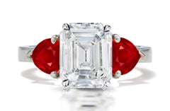 126 custom made unique emerald cut diamond center stone and heart ruby side three stone engagement ring