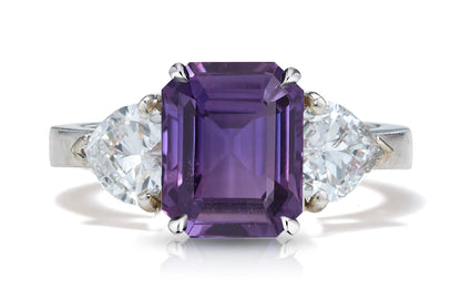 127 custom made unique emerald cut purple sapphire center stone and heart diamond side three stone engagement ring