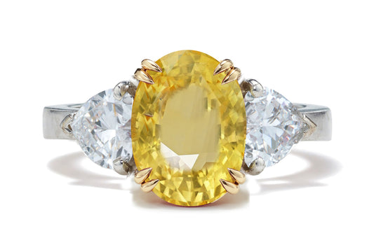 128 custom made unique oval cut yellow sapphire center stone and heart diamond side three stone engagement ring