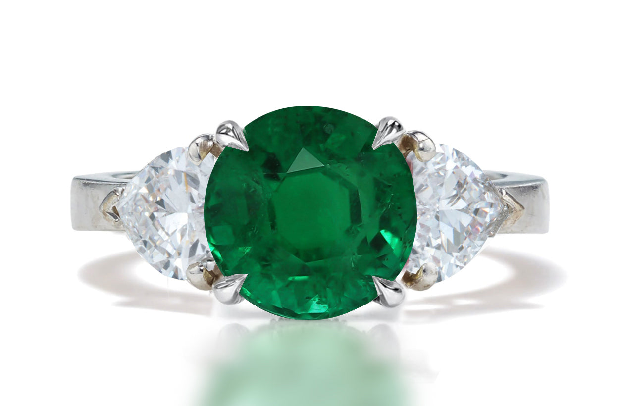 131 custom made unique round emerald center stone and heart diamond side three stone engagement ring