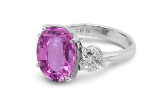 209 custom made unique oval cut pink sapphire center stone and heart diamond side three stone engagement ring