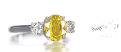 212 custom made unique oval yellow sapphire center stone and round diamond side three stone engagement ring.