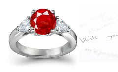 engagement ring with round ruby and side pear shaped diamonds