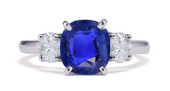 231 custom made unique oval blue sapphire center stone and round diamond side three stone engagement ring