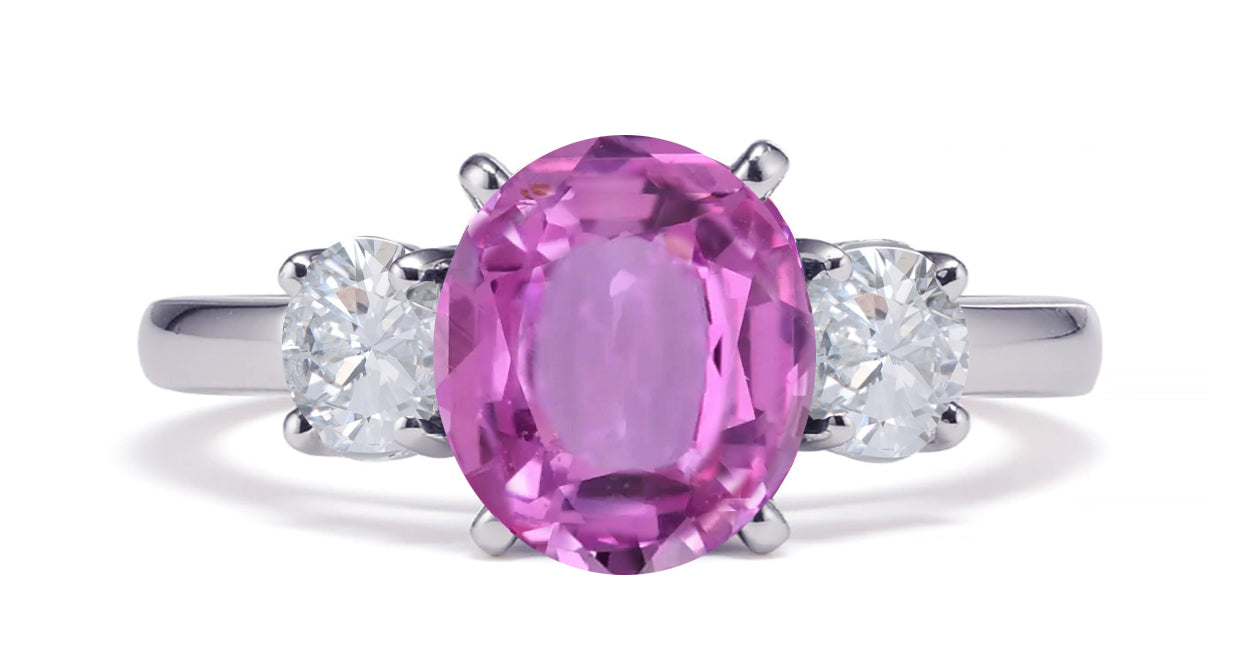 231 custom made unique oval pink sapphire center stone and round diamond side three stone engagement ring