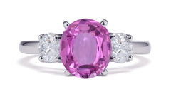 231 custom made unique oval pink sapphire center stone and round diamond side three stone engagement ring