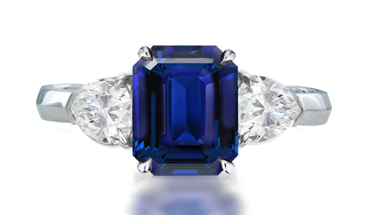 33 custom made unique emerald cut blue sapphire center stone with pear diamond accents three stone engagement ring