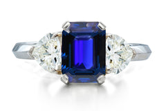 517 custom made unique emerald cut blue sapphire center stone and heart diamond accent three stone engagement ring