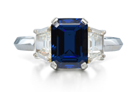 518 custom made unique emerald cut blue sapphire center stone and trapezoid diamond accent three stone engagement ring