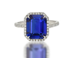 555 custom made unique emerald cut blue sapphire center stone and round diamond halo engagement ring