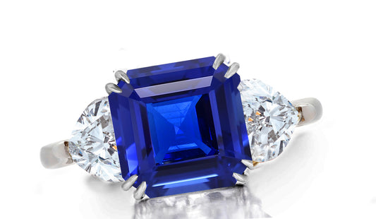 641 custom made unique asscher blue sapphire center stone and heart diamond accent three stone engagement ring.