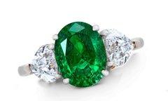 656 custom made unique oval emerald center stone and heart diamond accent three stone engagement ring