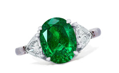 658 custom made unique oval emerald center stone and trillion diamond accent three stone engagement ring