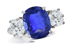 663 custom made unique oval blue sapphire center stone and round diamond accent three stone engagement ring