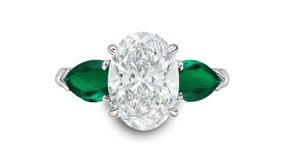 86 custom made unique oval diamond and pear shaped emerald side three stone engagement ring