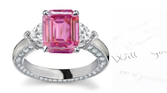 engagement ring handcrafted with emerald cut pink sapphire center and side heart diamonds