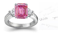 engagement ring with emerald cut pink sapphire center and side heart diamonds