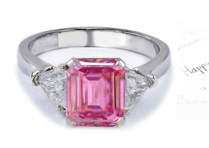 engagement ring with emerald cut pink sapphire center and side trillion diamonds