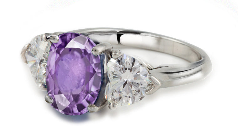 engagement ring three stone with oval purple sapphire center and side heart diamonds