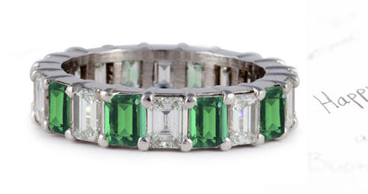 eternity ring prong set with emerald cut emeralds and diamonds