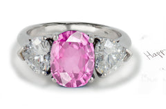 engagement ring three stone with oval pink sapphire center and side heart diamonds