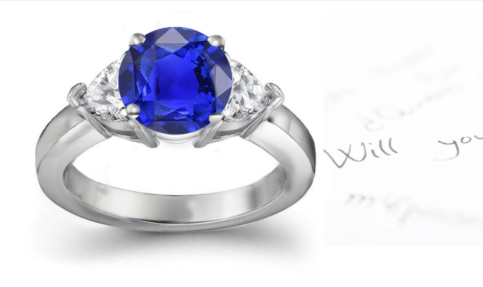 engagement ring with round blue sapphire center and side heart diamonds