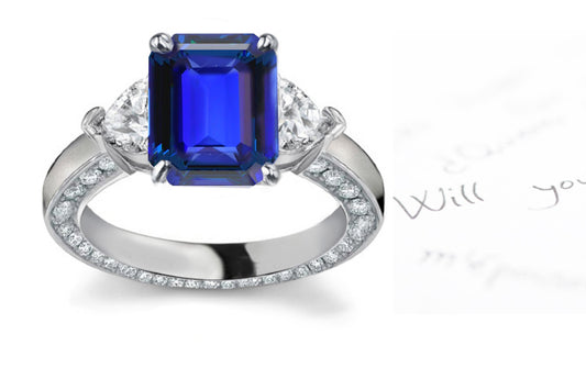 engagement ring handcrafted with emerald cut blue sapphire center and side heart diamonds